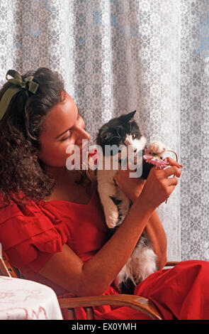 Young Latin-American woman cuddling male kitten Stock Photo