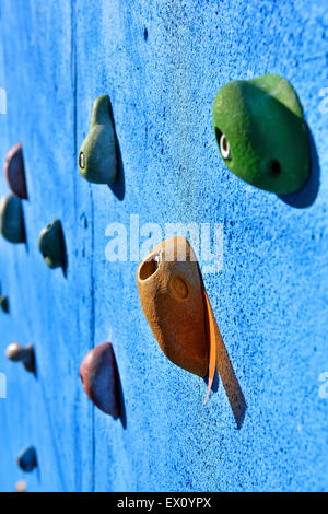 blue climbing wall with toe and hand hold studs Stock Photo