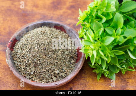 Dried and fresh basil arranged on a table in old kitchen bowl Stock Photo