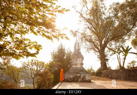 A young monk by Wat Siphoutthabat Thipphuramm at dawn. Luang Prabang , Laos. Stock Photo