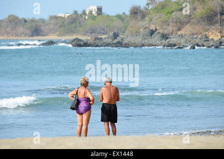 Older couple in front of a tropical beach Stock Photo