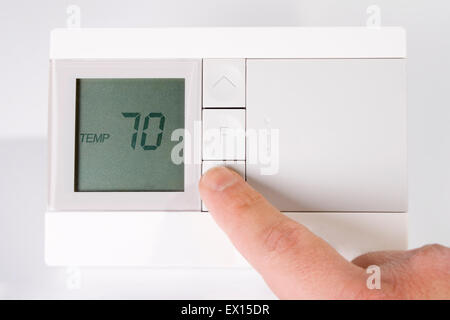 Stock image of hand adjusting thermostat Stock Photo