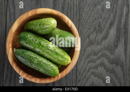 whole cucumbers in olive dowl on wood table Stock Photo
