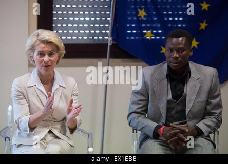 Catania, Sicily, Italy. 4th July, 2015. German Defence Minister Ursula von der Leyen (CDU) speaks next to a refugee from Ghana during a visit to the 'Seenotrettung MED' (lit. sea rescue MED) Bundeswehr mission, in Catania, Sicily, Italy, 4 July 2015. Photo: SOEREN STACHE/DPA/Alamy Live News Stock Photo