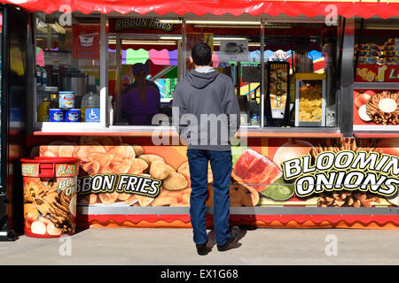 KId waiting at a food stand at a carnval Stock Photo
