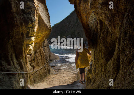 Tourist inside cave used for filming in Poldark Stock Photo