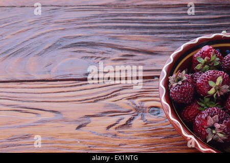 on a wooden board can be seen part of the dish with a dark red strawberries Stock Photo