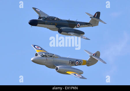 Gloster Meteor T.7 and Gloster Meteor NF.11 jet aircraft in RAF colours displaying at Baginton Air Pageant, Airbase, Coventry Airport, West Midlands, UK. The preserved silver Meteor T.7 trainer, built in 1949, is the world's oldest flying British jet aircraft. The slightly younger camouflaged Meteor NF.11 night fighter was built in 1952. Credit:  Antony Nettle/Alamy Live News Stock Photo