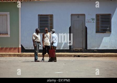 Three men stand and talk in Remedios, Cuba Stock Photo