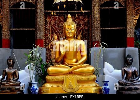 Chiang Mai, Thailand:   Gilded Buddha statue seated in the lotus position with uplifted hand at Wat Sum Pao Stock Photo