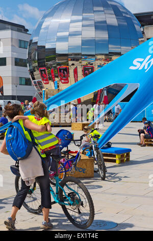 Family at Sky Ride bike event in Bristol Millennium Square with Mirrored Sphere Planetarium in background Stock Photo