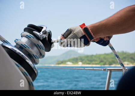 Winch and sailors hands on a sailboat. Shot with a selective focus Stock Photo