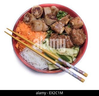Bowl of beef Bo bun with salad, porc ribs, fresh herbs and chinese chopsticks Stock Photo