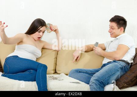 Young man winning card game beating the girl in poker. Couple playing games on their bed. Young woman doesn't believe that she i Stock Photo