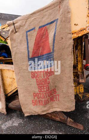 Hessian sacks for Scottish basic seed potatoes hang from a potato planter Stock Photo