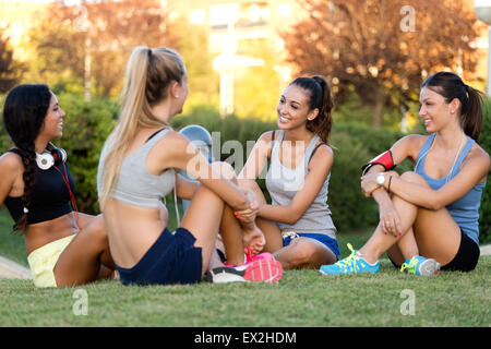 Outdoor portrait of running girls having fun in the park with mobile phone. Stock Photo