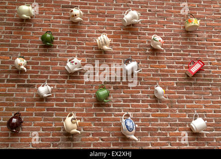 All kinds of teapots hanging on a wall as a decoration in the city of Oudewater, Utrecht, The Netherlands. Stock Photo