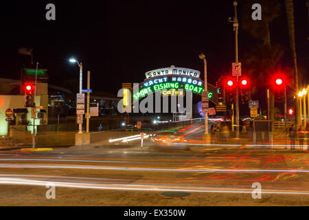 The iconic sign for the Santa Monica Pier glows neon at night. Stock Photo