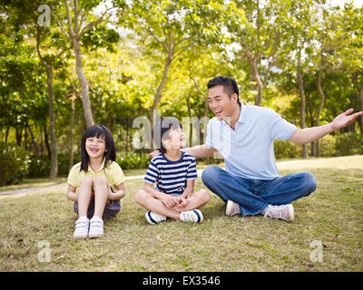 asian father and children having fun in park Stock Photo