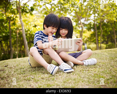 children using ipad outdoors Stock Photo