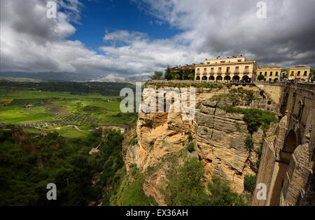 Dappled sunshine on green farm fields below the new bridge at El Tajo Gorge Ronda Spain Stock Photo