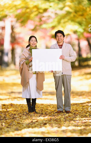 Senior Japanese couple with whiteboard in a city park Stock Photo - Alamy