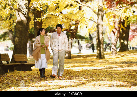 Senior Japanese couple in a city park in Autumn Stock Photo