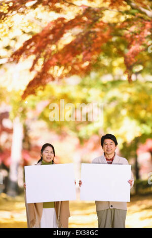 Senior Japanese couple with whiteboard in a city park Stock Photo - Alamy