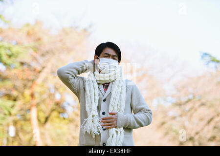 Senior Japanese man with mask feeling sick Stock Photo