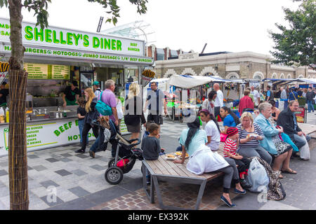 Shoppers seated beside a food stall at a Saturday market in Stockton on Tees, Co. Durham UK Stock Photo