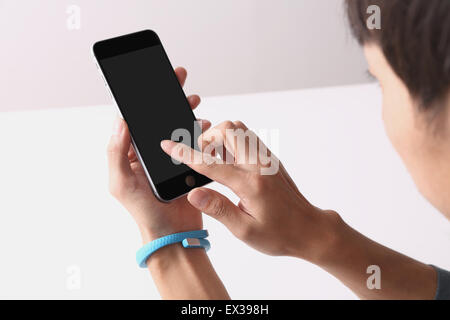 Young Japanese man using smartphone Stock Photo