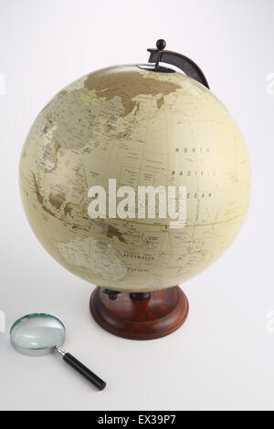 World globe and magnifying glass Stock Photo