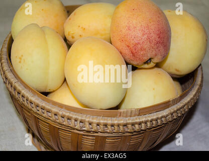 Yellow apricots in a woven basket Stock Photo