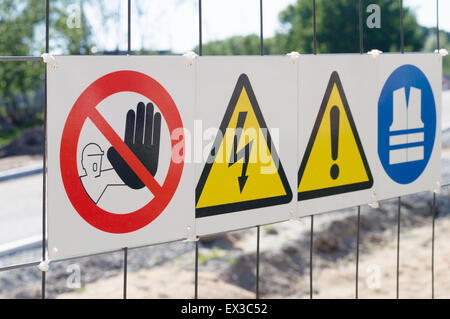 Warning signs on fence at construction site Stock Photo