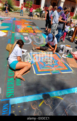 Two young female artists painting a mandala at the annual Imadonnari street painting festival in Santa Barbara CA Stock Photo