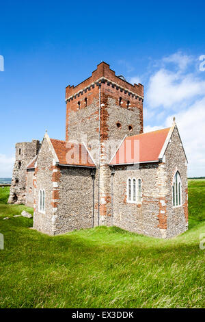 The ruins of the 2nd century Roman lighthouse, Pharos, with the stone church of St Mary in Castro church at Dover castle under blue summer sky. Stock Photo