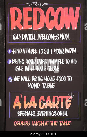 Sign outside The Red Cow public house, pub, bar, in the English town of Sandwich, offering A'la Carte food, served inside Stock Photo