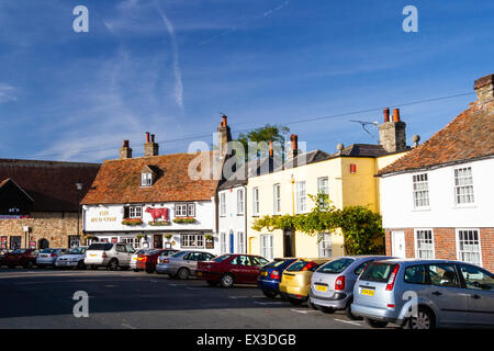 Sandwich in England. View along street to the Red Cow pub, a early 18th century two story building with tiled roof. Cars parked in front. Daytime. Stock Photo