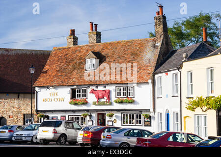 Sandwich in England. View along street to the Red Cow pub, a early 18th century two story building with tiled roof. Cars parked in front. Daytime. Stock Photo