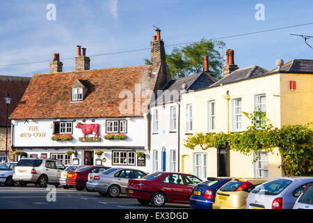 Sandwich in England. View along street to the Red Cow pub, a early 18th century two story building with tiled roof. Cars parked in front. Daytime. Stock Photo