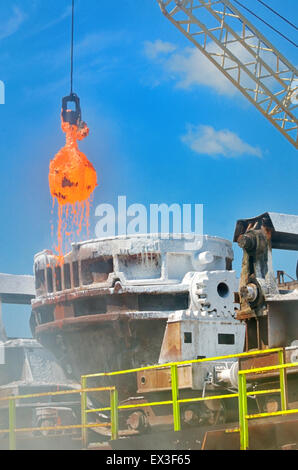 The molten slag is poured from a bucket molten on a railway platform Stock Photo