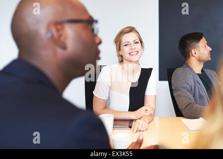 White female executive smiling at camera during a work meeting. Stock Photo