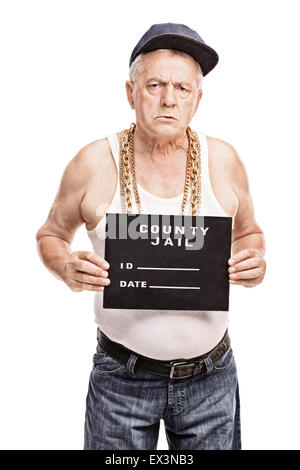Vertical shot of a senior gangster in a hip hop outfit posing for a mug shot isolated on white background