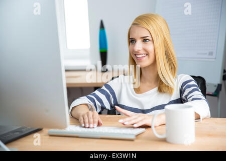 Happy female designer working on computer in office Stock Photo
