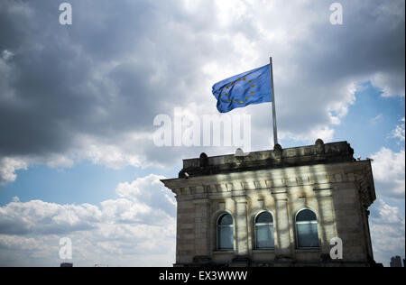 Berlin, Germany. 06th July, 2015. A flag of the European Union flies on the rooftop of the Reichstag, the German parliamentary building, with dark clouds hovering above it, in Berlin, Germany, 06 July 2015. Photo: Bernd von Jutrczenka/dpa/Alamy Live News Stock Photo