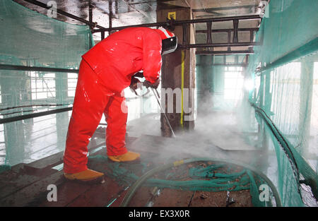 A contractor uses a high pressure water jet to remove concrete whilst repairing the support structure to the Woolwich Ferry vehicle ramp. London, UK. Stock Photo