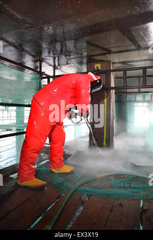 A contractor uses a high pressure water jet to remove concrete whilst repairing the support structure to the Woolwich Ferry vehicle ramp. London, UK. Stock Photo