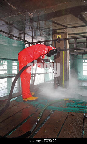 A contractor uses a high pressure water jet to remove concrete whilst repairing the support structure to the Woolwich Ferry vehicle ramp. London, UK. Stock Photo