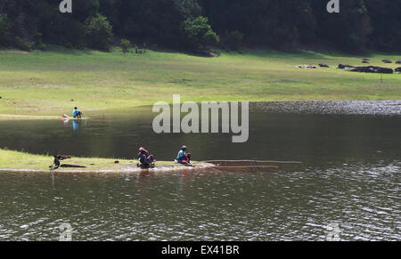 Tribal women fishing on the bank of the Thekkady Lake, along the wildlife sanctuary at Periyar Tiger Reserve. Stock Photo