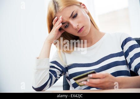 Unhappy casual woman holding bank card Stock Photo